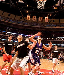 A Kellogg School basketball player braces for the rebound amid Booth defenders during the annual “Running of the Bulls” game at Chicago’s United Center on Feb. 24.