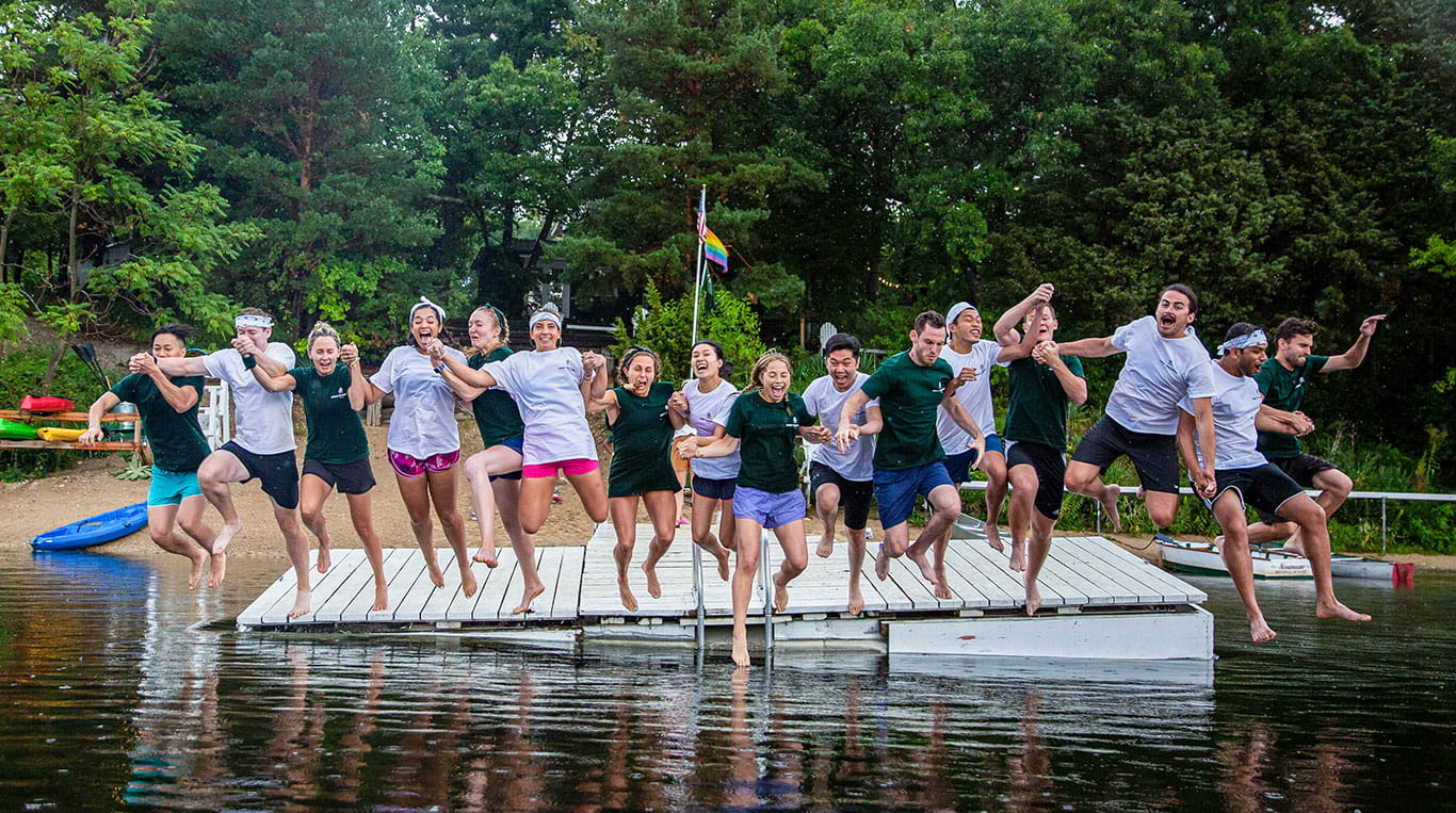 Kellogg MBA students jumping into a lake during a class trip