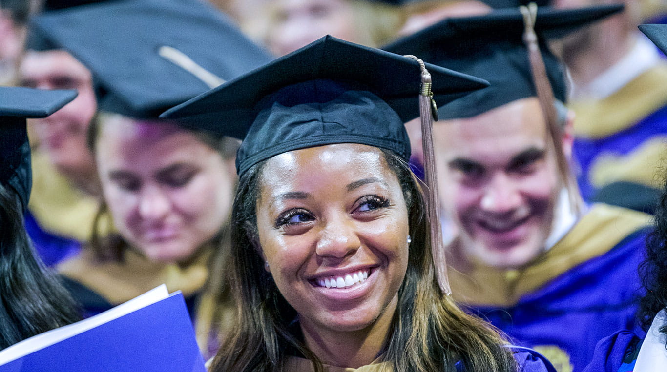 An MBA student smiling in cap and gown at Convocation