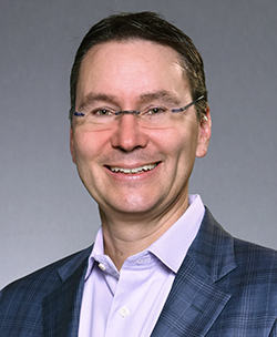 A person wearing glasses and a suit
AI-generated content may be incorrect.