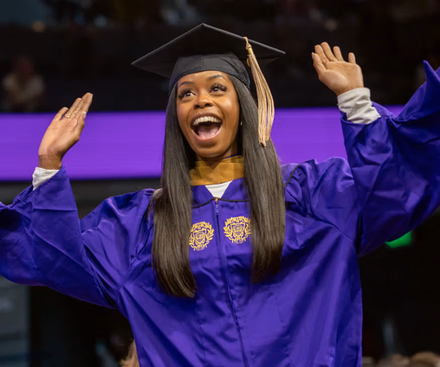 A Kellogg graduate celebrates while walking across the stage at convocation 