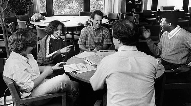 1969: Women and men in discussion around a table at Kellogg