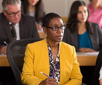 Attentive Kellogg Executive Education participant seated with pencil in hand at the James L Allen Center