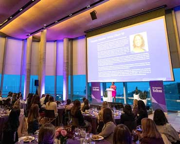 Presenter speaking to a large audience at the Women in Finance dinner