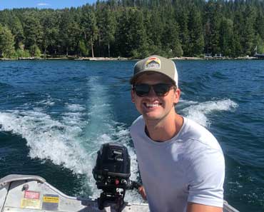 Finance Fellow Tanner Montgomery, pictured driving a small boat in a lake