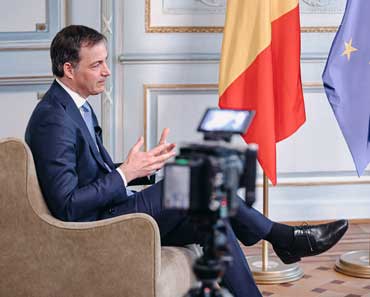 Alumnus Alexander De Croo seated and giving a television interview