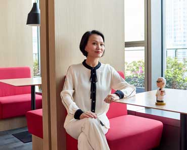 Alumna Joy Wat seated in a fast-casual restaurant