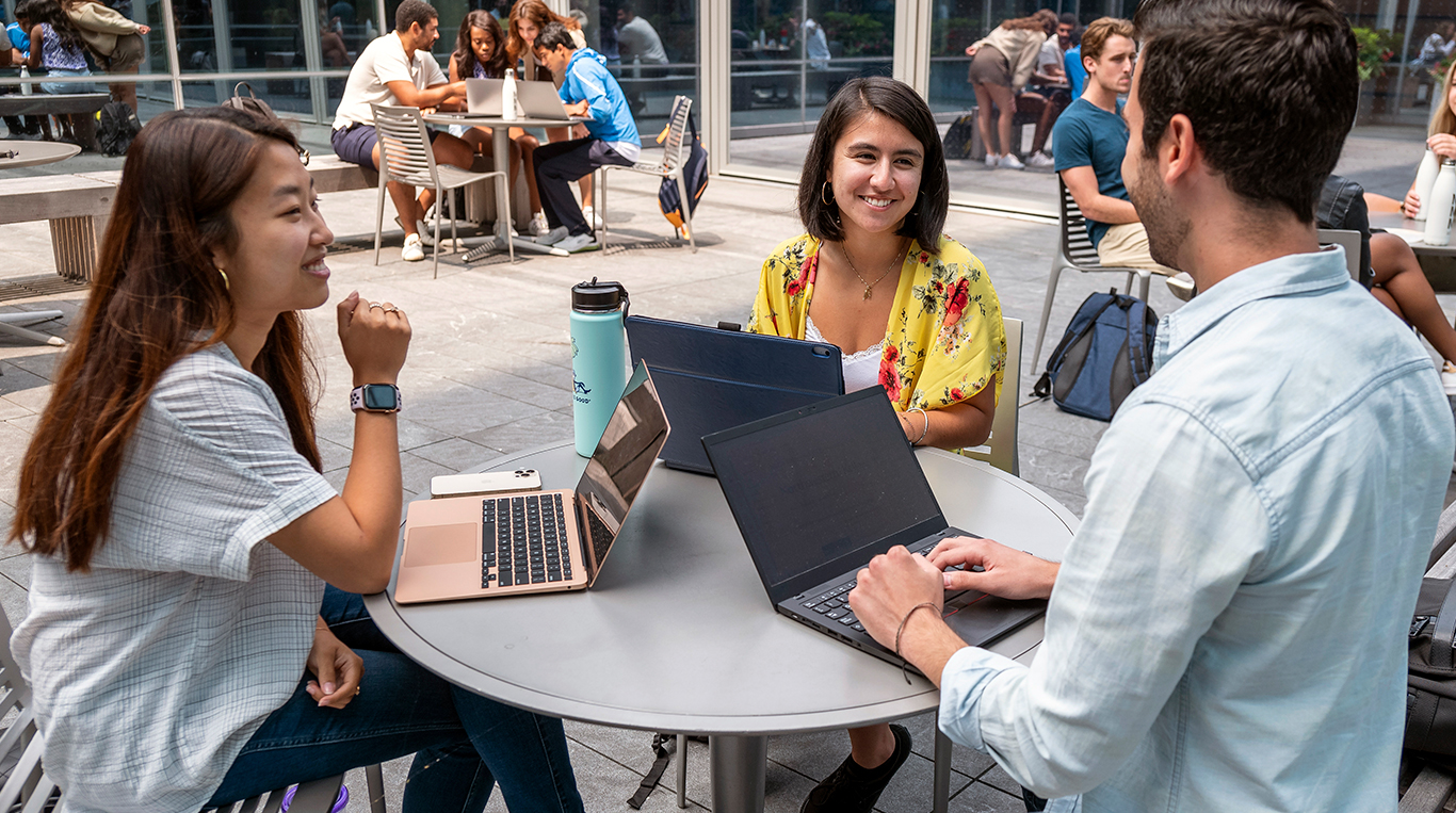Kellogg students sit on patio working together
