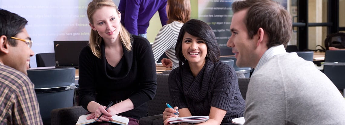 A group of students work together in a conference room.