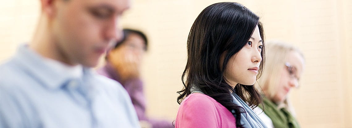 A young woman in a pink shirt participates in the Kellogg two-year MBA program.