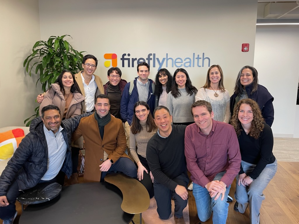 A group of students posing in in front of an office titled Firefly Health