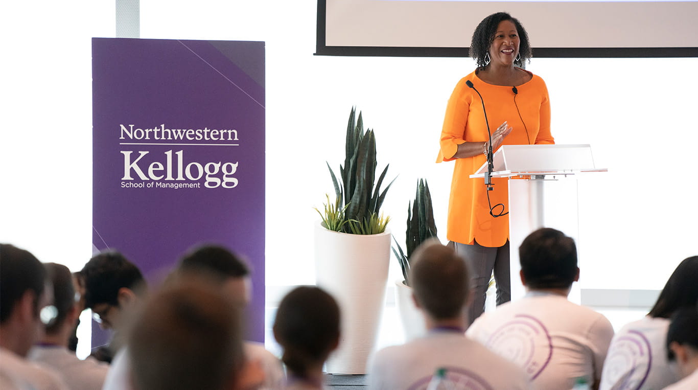 Dorri McWhorter speaking at a podium in front of an audience at the Kellogg Global Hub