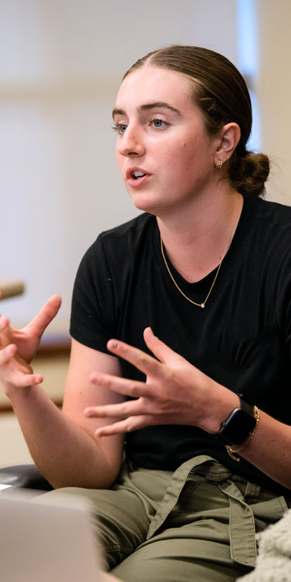 Student explains their thoughts during a class at Kellogg as other students listen.