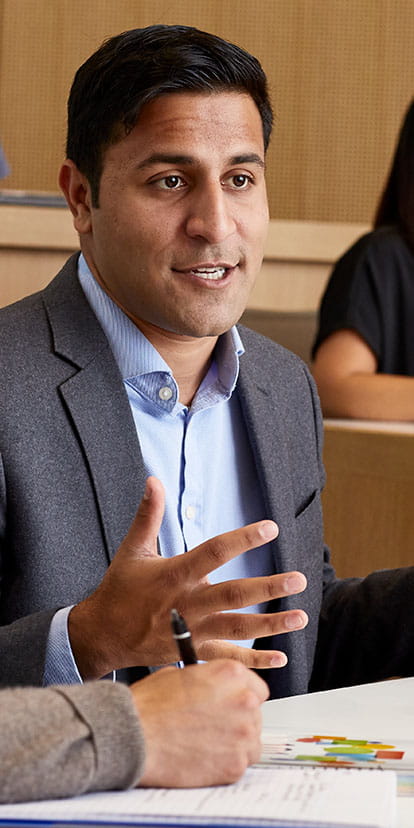 Kellogg students in discussion and working in a classroom