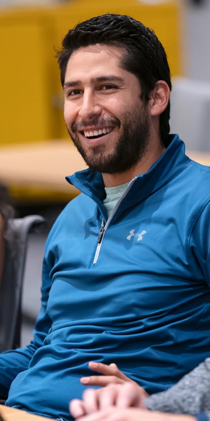 Smiling Kellogg student seated in a Global Hub classroom at the Evanston campus