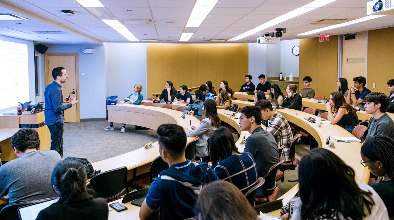 Students listen to a lecture while seated in a classroom