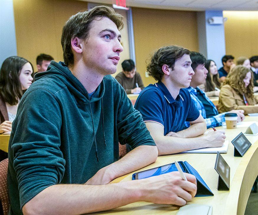 Several Kellogg Certificate Program for Undergraduate students seated at a curved desk in a classroom