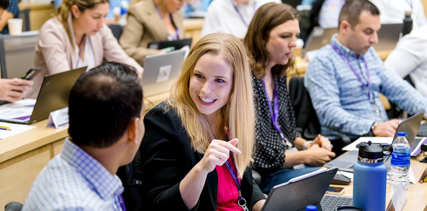 people network with each other sitting in the front row of a Northwestern University classroom