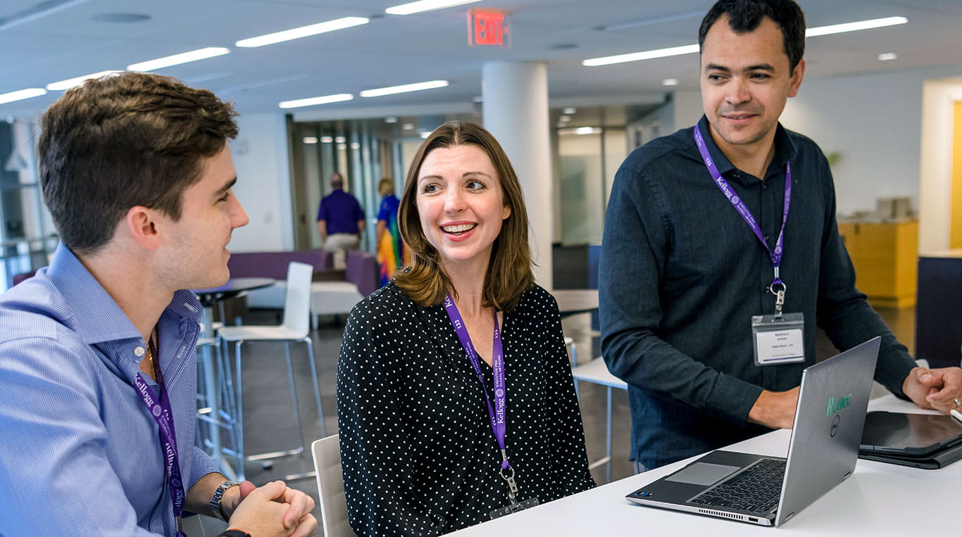 three students smile while speaking with each other