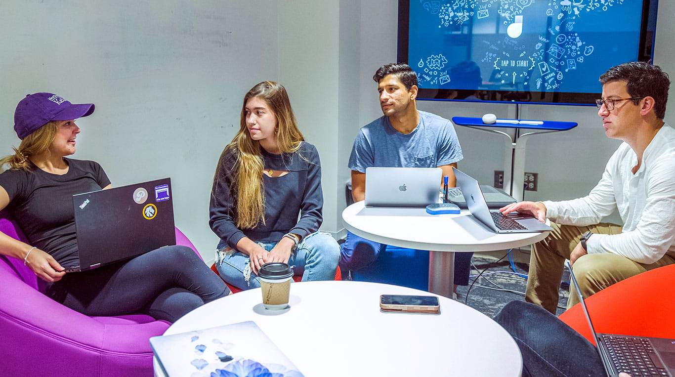 MBAi students talking around a table