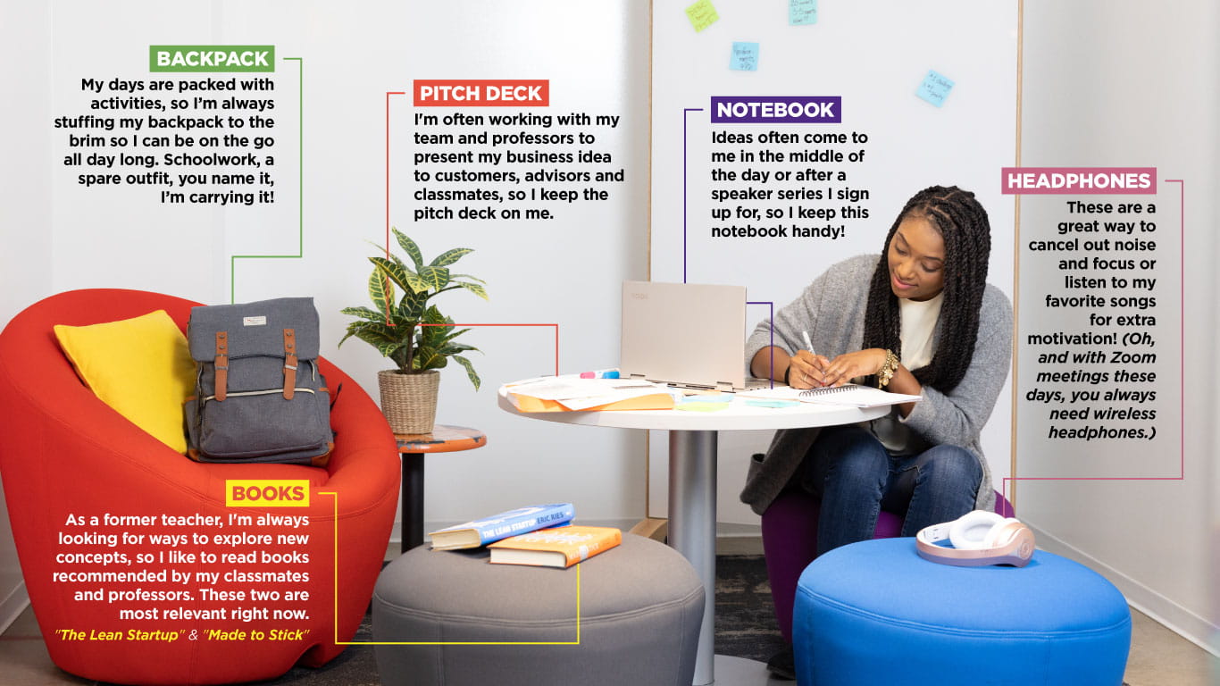 Ashley Abraham sitting at a table in the startup incubator in The Garage with brightly colored chairs nearby