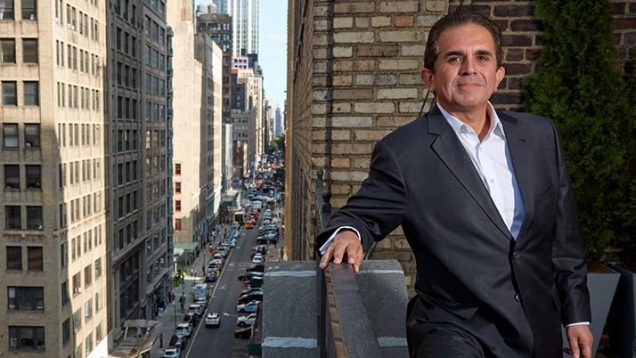 Kellogg alumnus Daniel Gamba stands on a balcony overlooking a busy city street