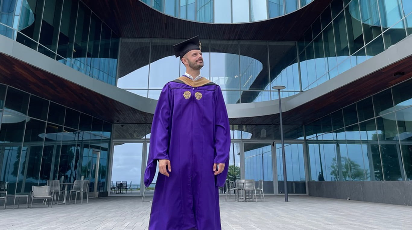 MBA graduate Nathan Alan Marks stands in front of the Hub