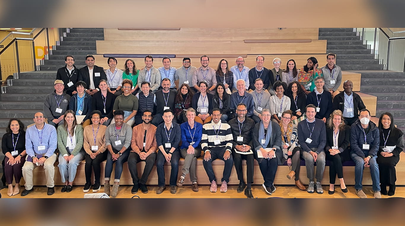 Recent class of Youn Impact Scholars sits on the steps in the Kellogg Global Hub