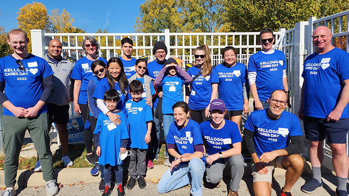 A group of Kellogg alumni volunteers in Chicago pose together for a group photo in matching blue t-shirts