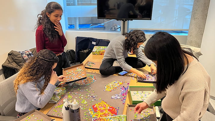 Professor Gina Fong and some of her students get together outside of classroom hours to take joy in completing a puzzle. 