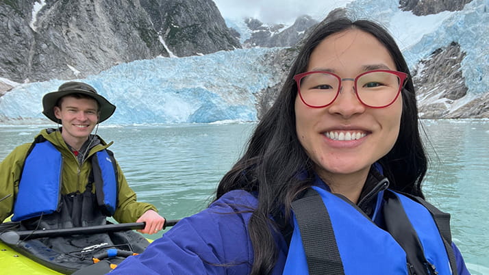Emily and her JV (spouse) kayaking through Alaska's icebergs