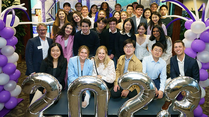 Students at graduation posing with balloons that say "2023"