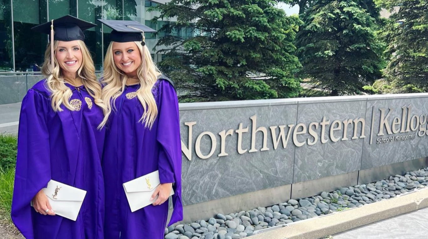 Two Kellogg graduates in purple robes and graduation caps standing side by side.