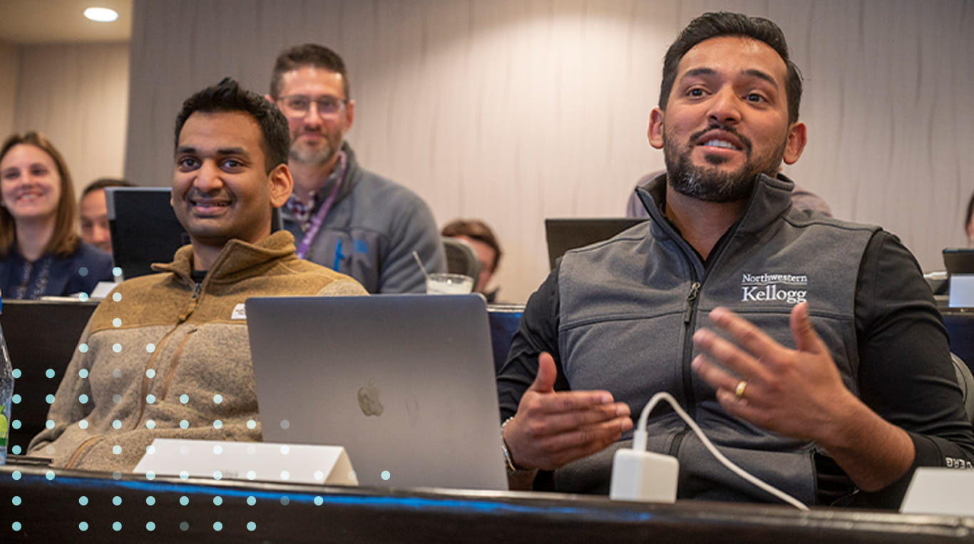 A student wearing a gray vest with a Kellogg logo speaks while participating in the Healthcare Deep Dive course