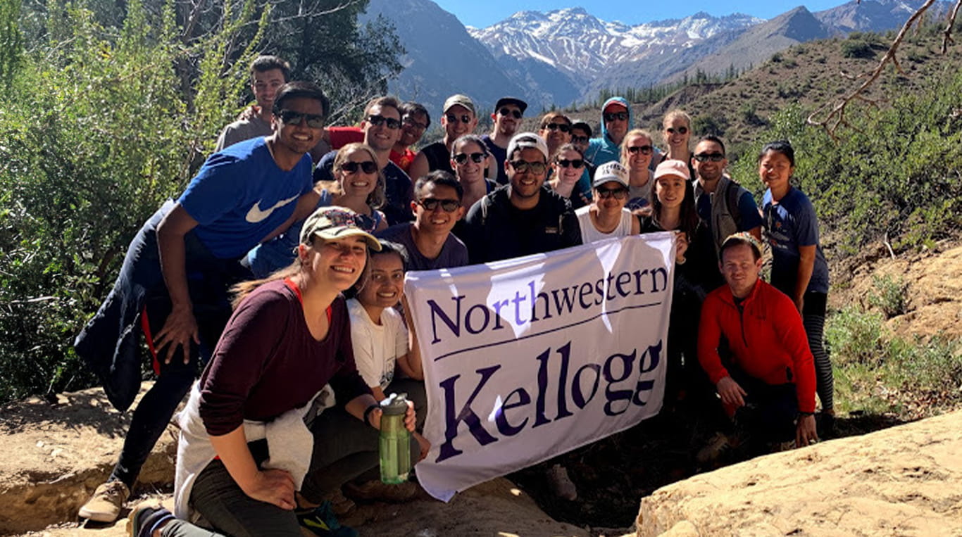 Kellogg students go on a hike and proudly take their school's flag along with them.