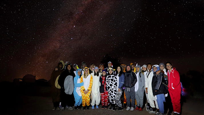 Sam and other Kellogg MBA students pose for a picture under the stars during their KWEST trip in the Atacama Desert.