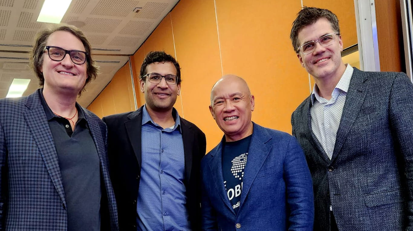 Four participants stand together and smile while taking a Kellogg Executive Education course. They include Kellogg alumnus Ernest Cu ’84 MBA.