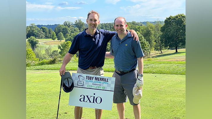 Axio CEO Scott Kannry and COO Daniel Hirt pose with an Axio sign at a golf outing