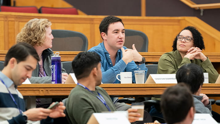 Group of Kellogg graduates and Youn Impact Scholars discussing forward-looking topics, such as the impact of climate change on the future of work.