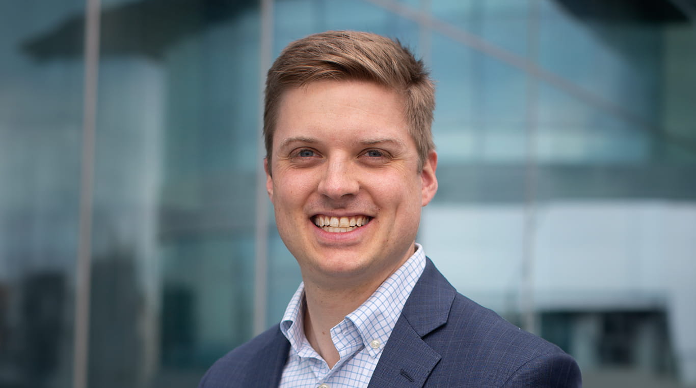 Kellogg alumnus Michael Koniares '22 MBA smiles while posing for a photo in front of the Kellogg Global Hub in Evanston, Illinois.