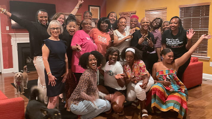 Alumna Ricki Fairley smiles and poses with friends and other breast cancer survivors.