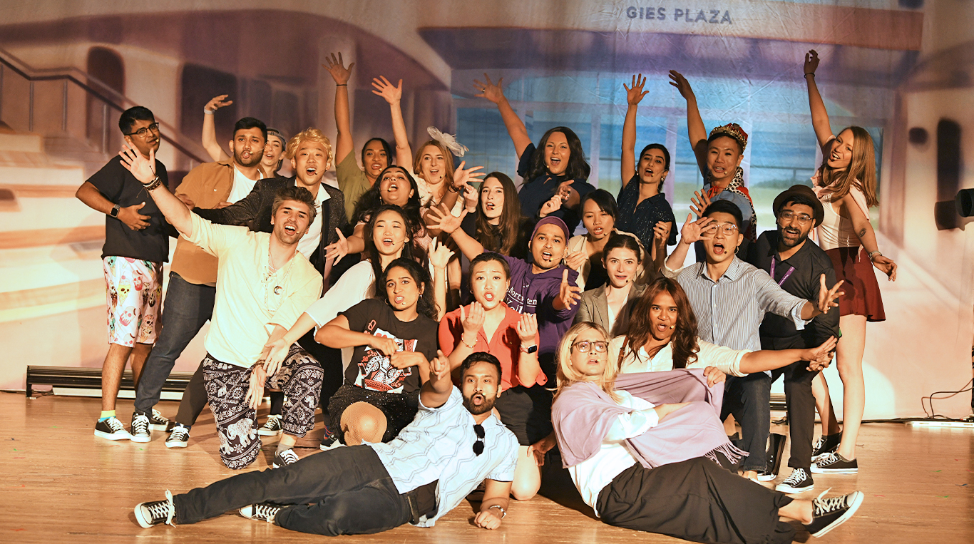 A group of MBA students posing on a stage.
