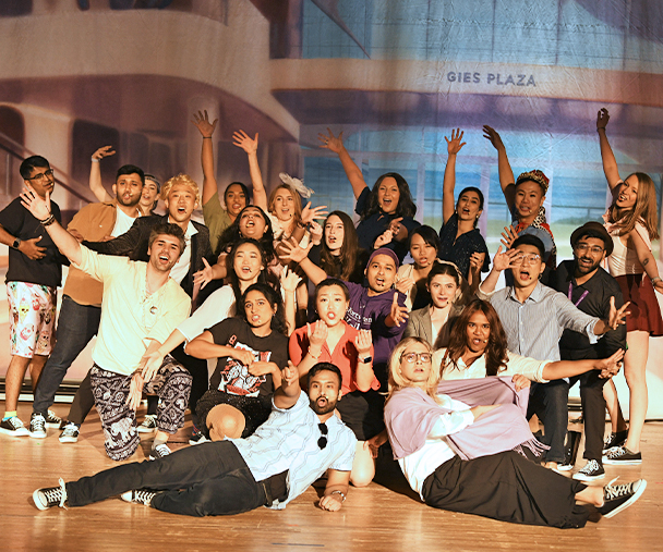 A group of MBA students posing on a stage.