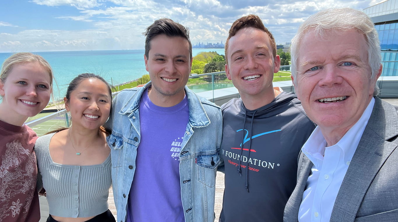 A group of five people posing for a selfie in front of Lake Michigan.