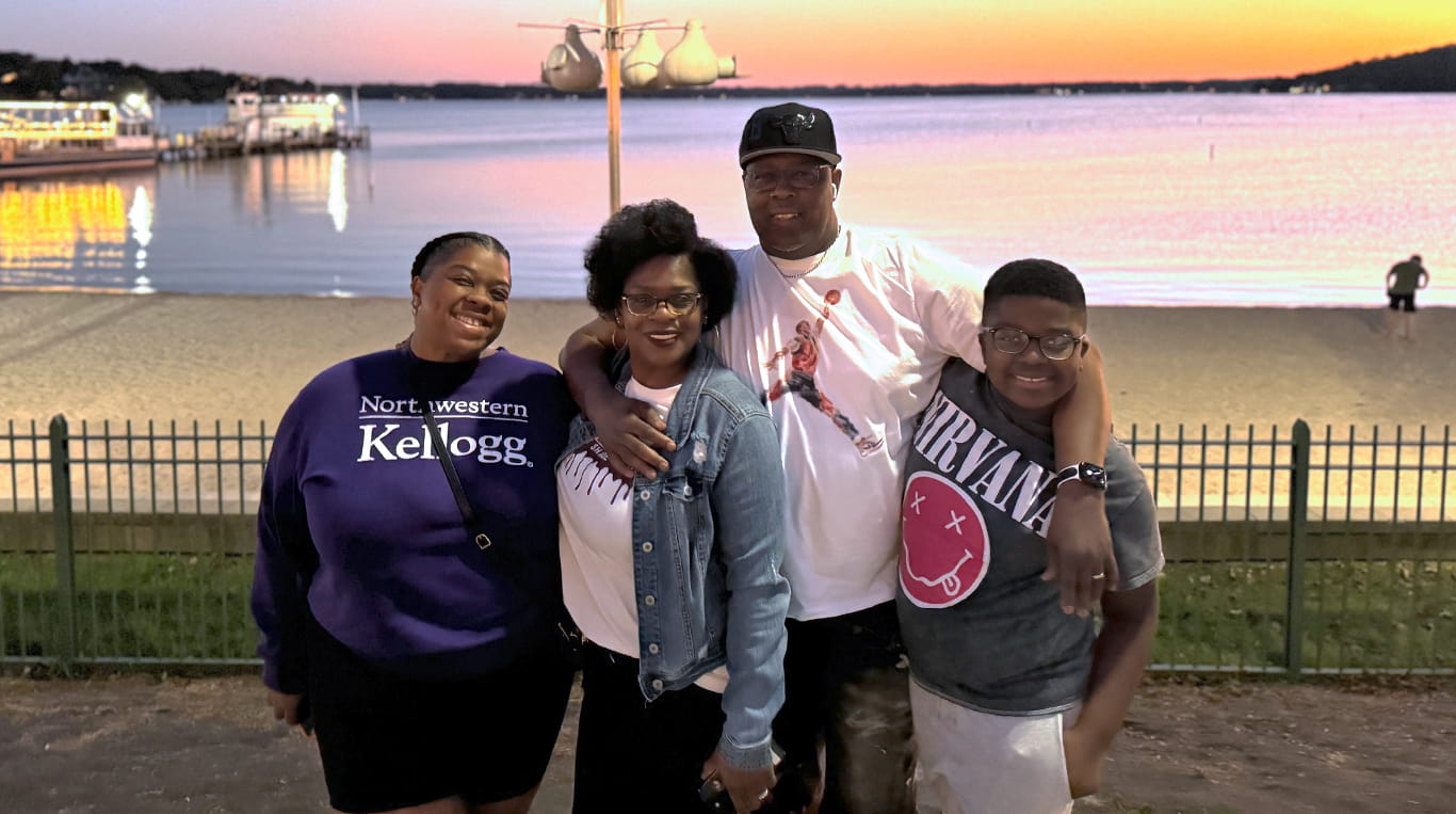 Executive MBA student LeVincia Porch ’26 (left, Kellogg sweatshirt) with her family in front of a lake