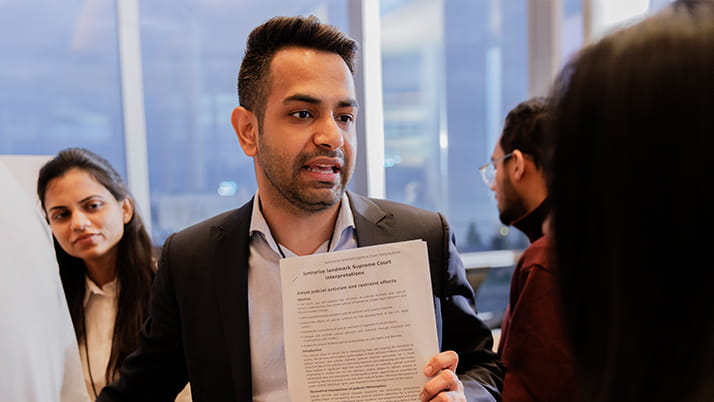Kellogg MBAi student discussing his capstone project with event attendee.