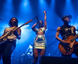 Two men and a woman performing on a stage