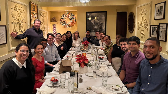 Kellogg students sit a long table together at dinner while on a Levy Trek trip in San Francisco