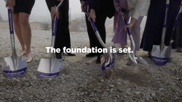 Kellogg leaders and friends participate in the ceremonial turning of the earth. The image has a shaded overly and white text reading, "The foundation is set."