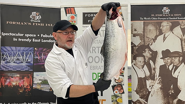 A man at H. Forman & Son Salmon Factory holding a fish